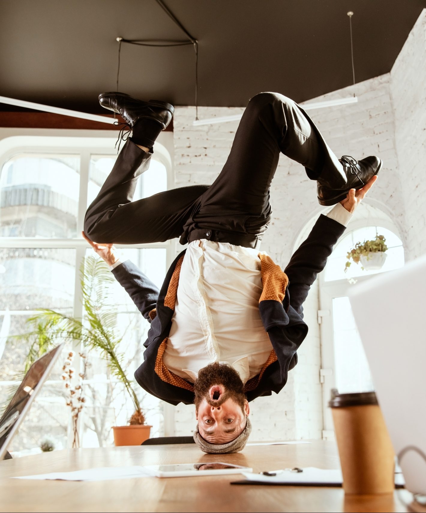 Keeping your best talent. Image: Businessman doing a headstand over a meeting table